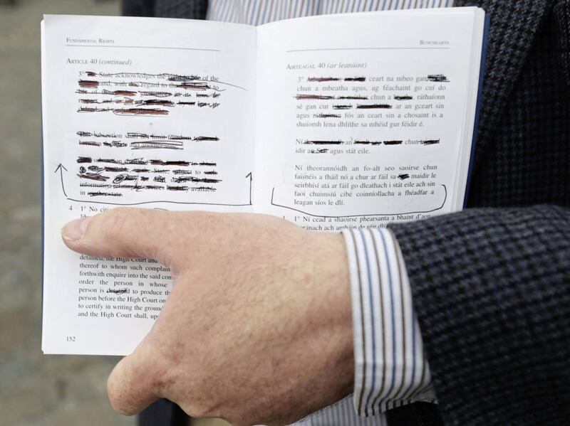 A man holds redacted copy of of the Irish Constitution at Dublin Castle on Saturday after the Republic voted to change its abortion restrictions 