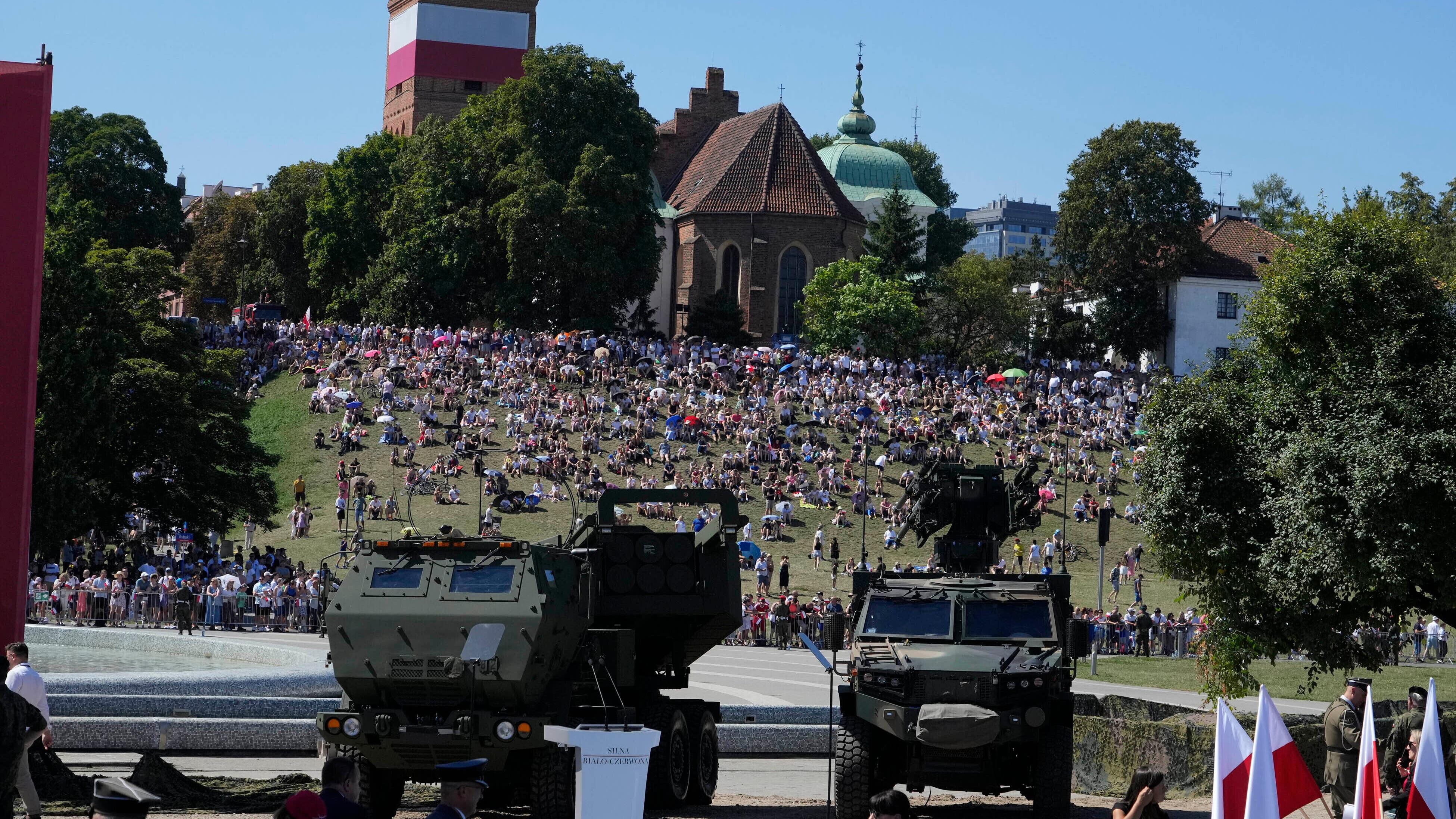 People watch a massive military parade (Czarek Sokolowski/AP)