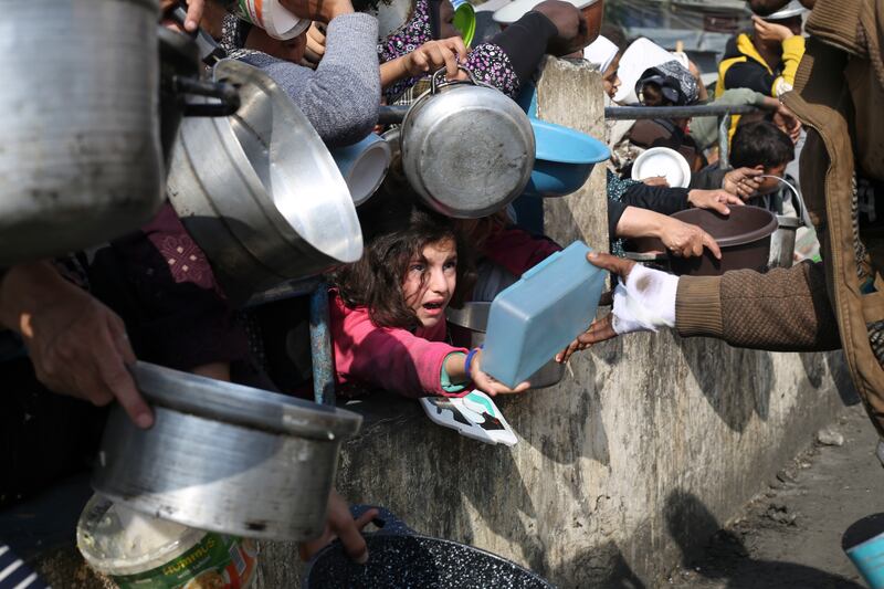 Palestinians line up for food aid in Rafah (Hatem Ali/AP)