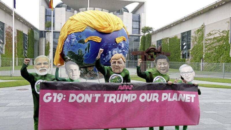 Demonstrators of the Avaaz campaign protest against the climate policy of US president Donald Trump as they wear masks of Indian prime minister Narendra Modi, French president Emmanuel Macron, German chancellor Angela Merkel, Chinese president Xi Jinping and European Commission president Jean-Claude Juncker, from left, yesterday. Picture by Michael Sohn, Associated Press 