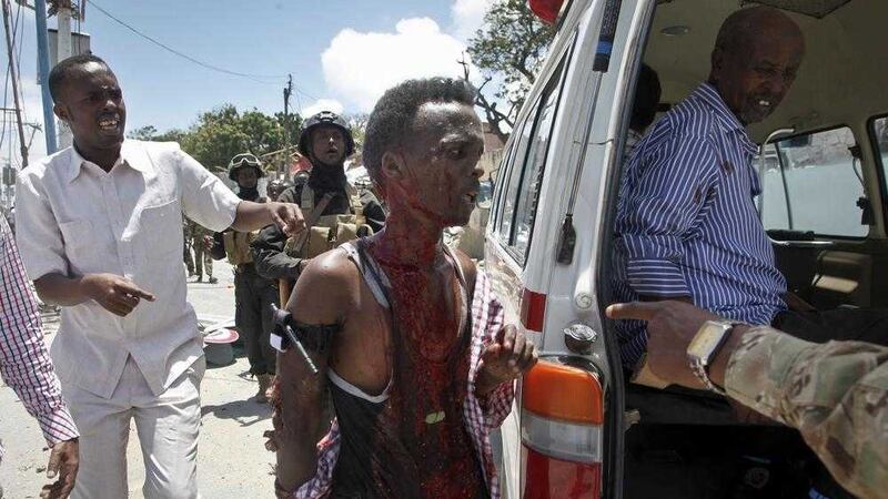 A man who was wounded by a blast near the presidential palace is helped into a vehicle in the capital Somalian Mogadishu. Picture by Farah Abdi Warsameh, Associated Press