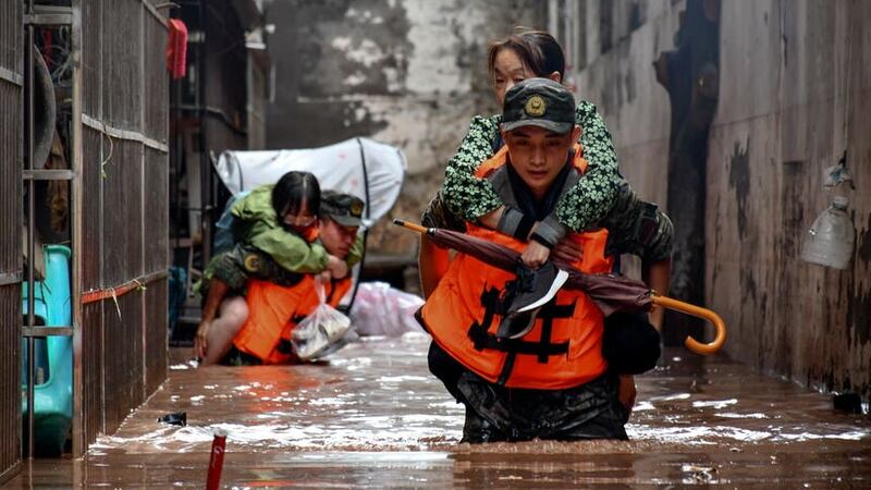 Members of the Chinese People’s Armed Police Force evacuate flood trapped residents in Wanzhou District (Xinhua via AP)