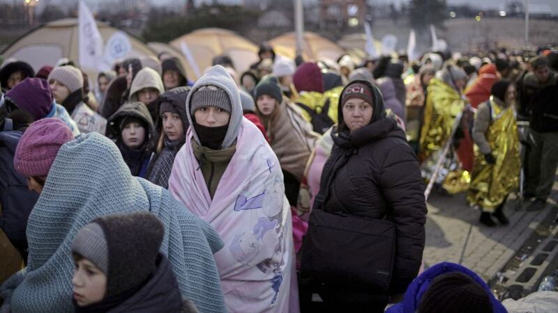 Refugees wait for transportation after fleeing from the Ukraine and arriving at the border crossing in Medyka, Poland. (AP Photo/Markus Schreiber). 