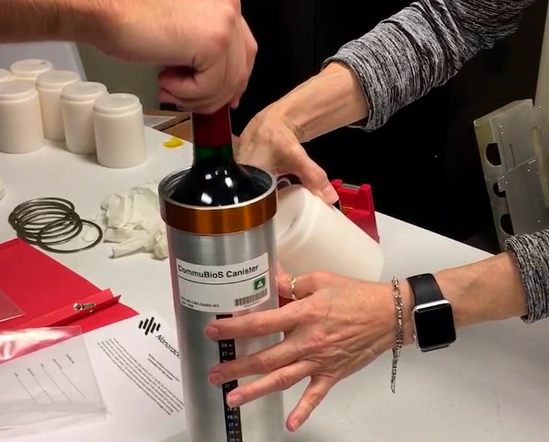 Researchers from the company prepare bottles of French red wine to be flown from Wallops Island to the International Space Station