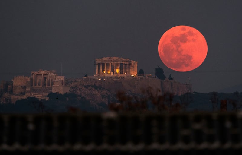 A super blue blood moon rises behind the Parthenon temple on the Acropolis of Athens, Greece (Petros Giannakouris/PA)