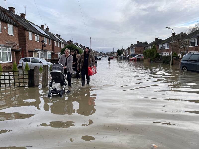 Residents wade through flood water in Loughborough, Leicestershire
