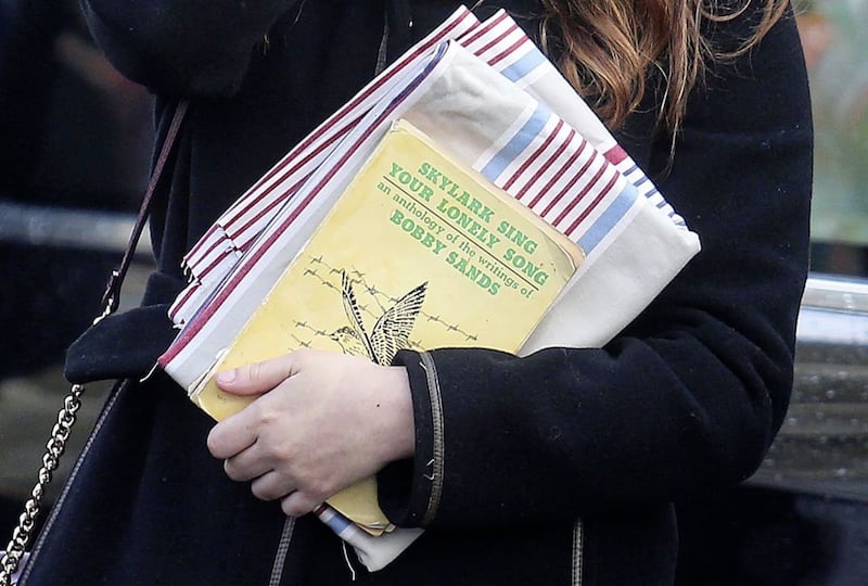 A girl carries the writings of Bobby Sands at the funeral of his mother Rosaleen Sands. Picture Mal McCann