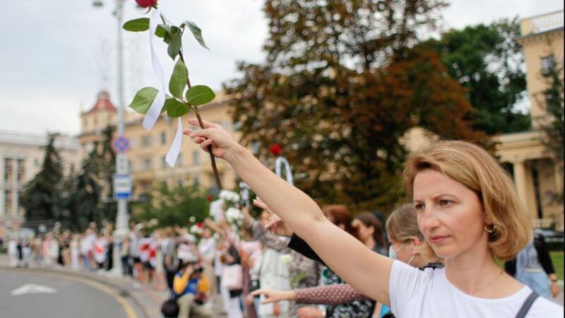 Belarusian opposition supporters hold flowers and flash victory signs during a protest in Victory Square in Minsk, Belarus, on August&nbsp;20 2020.&nbsp;President Alexander Lukashenko has extended his 26-year rule in a vote the opposition saw as rigged. Picture by&nbsp;Sergei Grits, AP Photo