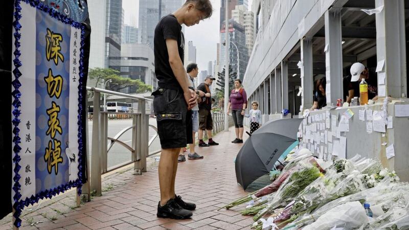 PROTESTS:A man pays respect on the site where a man fell to his death a day earlier after hanging a protest banner against the extradition bill on the scaffolding of a shopping mall in Hong Kong          Picture:       Vincent Yu/AP 