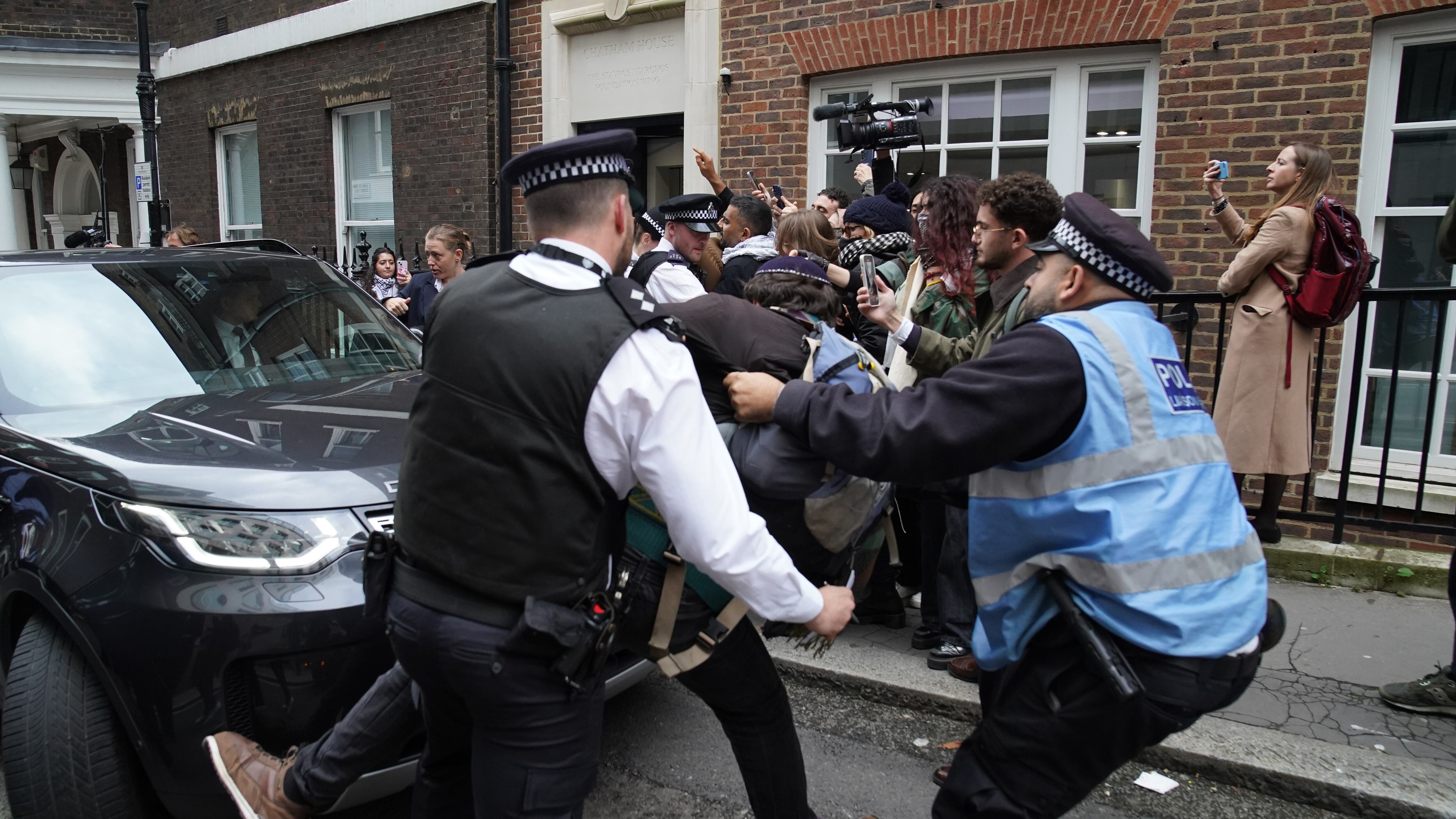Police officers move a man trying to block Labour leader Sir Keir Starmer’s car as he leaves, following his speech on the situation in the Middle East at Chatham House in central London (Stefan Rousseau/PA)