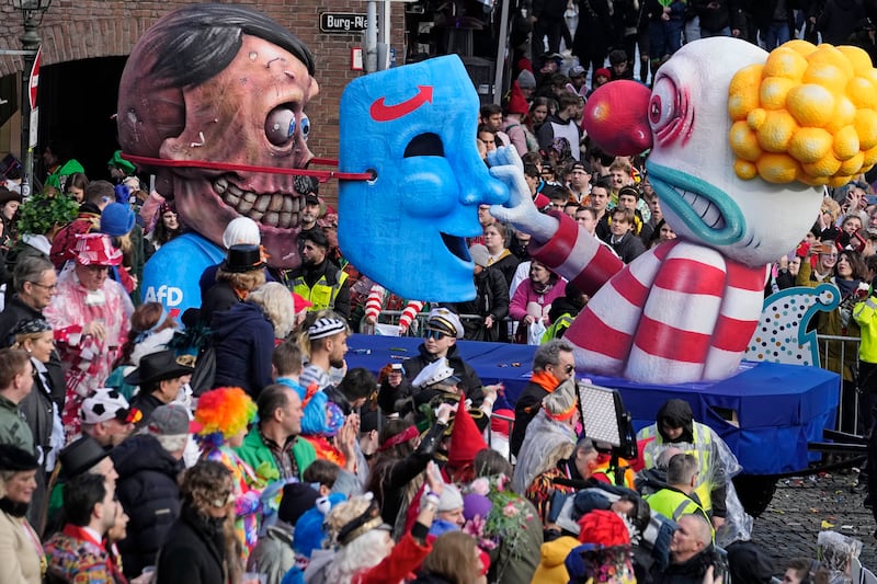 A carnival float depicts a reveller unmasking Adolf Hitler as AfD (Alternative for Germany) politician during the traditional carnival parade in Duesseldorf, Germany (AP Photo/Martin Meissner)