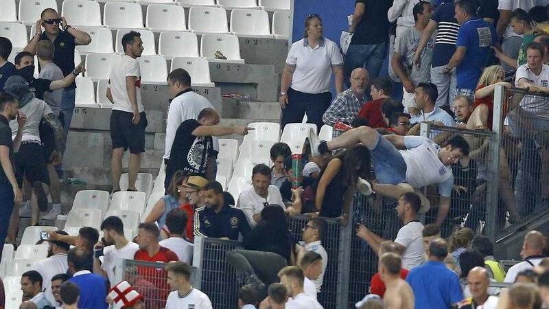 England supporters jump over a fence fleeing scuffles in the stands as Russian fans attacked the England fans at the end of the Euro 2016 Group B soccer match between England and Russia, at the Velodrome stadium