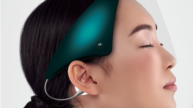 Woman wearing a Neurovalens headset with her eyes closed.