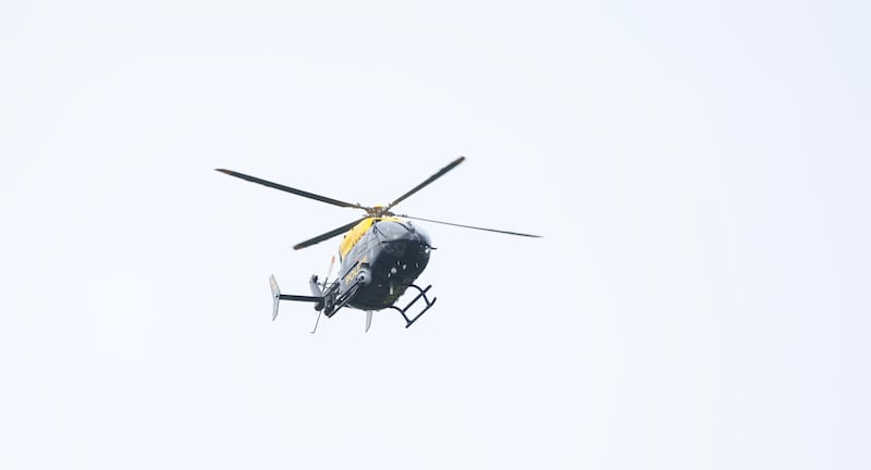 Police helicopter hovers over as cordons remain in place in the junction of Forglen Road and Ballyhanedin Road due to a security alert in the area. PICTURE COLM LENAGHAN