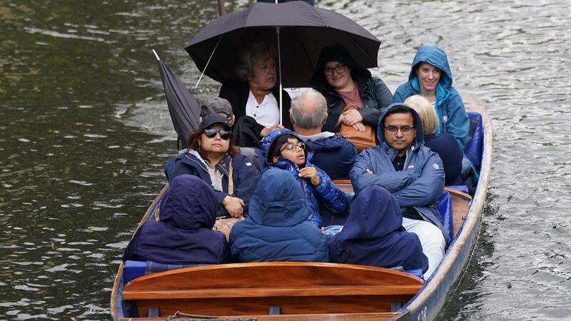 People wrap up against the rain on a punt on the River Cam in Cambridge (Joe Giddens/PA)
