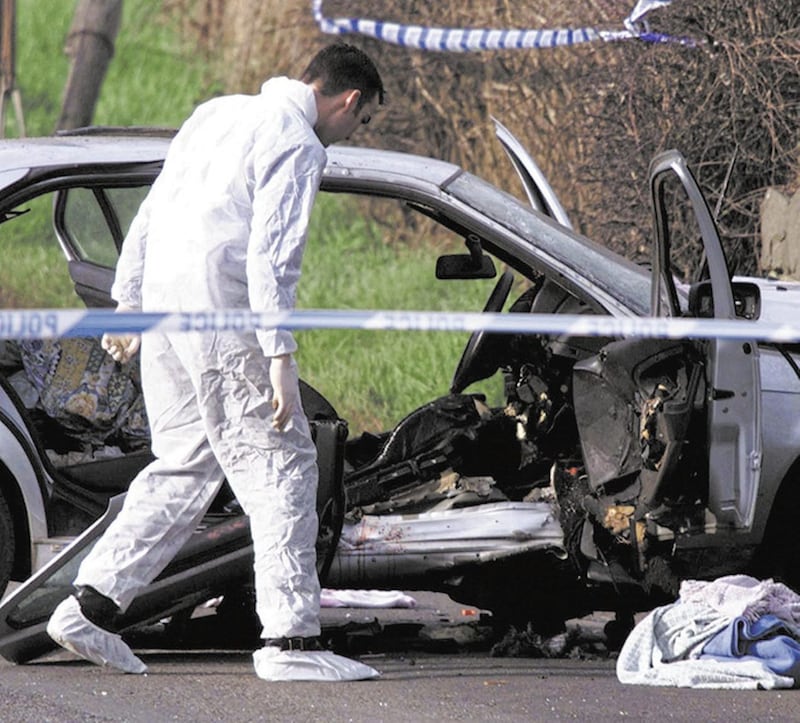 A forensic officer examines the vehicle in which Rosemary Nelson died in a car-bomb attack. Picture by&nbsp;Paul Faith, PA
