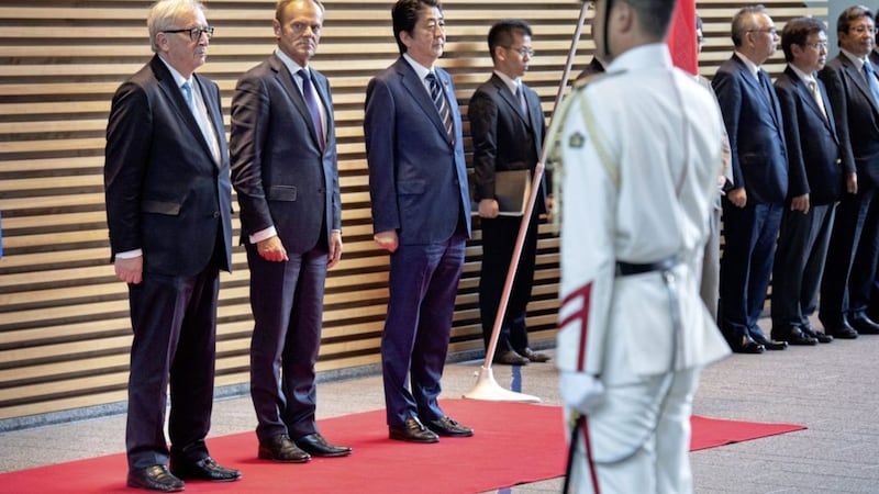 Japanese prime minister Shinzo Abe, centre right, European Union's Commission Jean-Claude Juncker, left, and European Union Council President Donald Tusk attend a welcoming ceremony on Tuesday. Picture by Martin Bureau, Associated Press