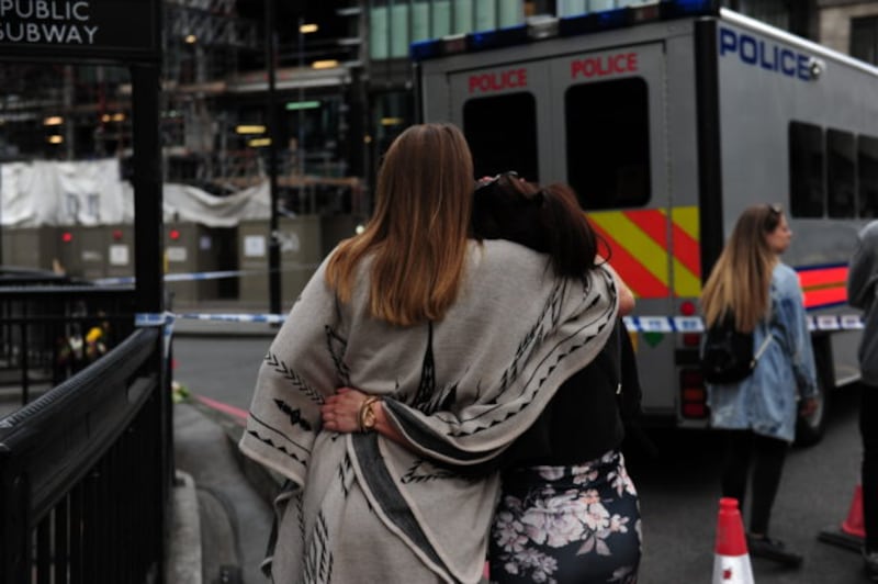 Two women hug after laying flowers in London Bridge