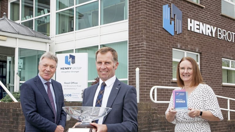 Kieran Harding (left), managing director of Business in the Community, presents the top award to Ian Henry, director at Henry Brothers, watched by the firm&#39;s HR manager Jennifer Cruickshank 