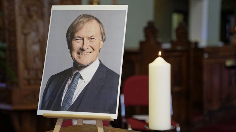 A candle and a picture of Conservative MP Sir David Amess who died after he was stabbed several times at a constituency surgery on Friday. Photo: Kirsty O&#39;Connor/PA Wire. 