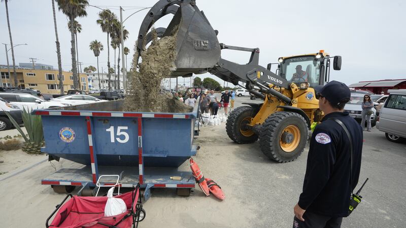Residents wait in line to fill up their sandbags in Long Beach (Damian Dovarganes/AP)