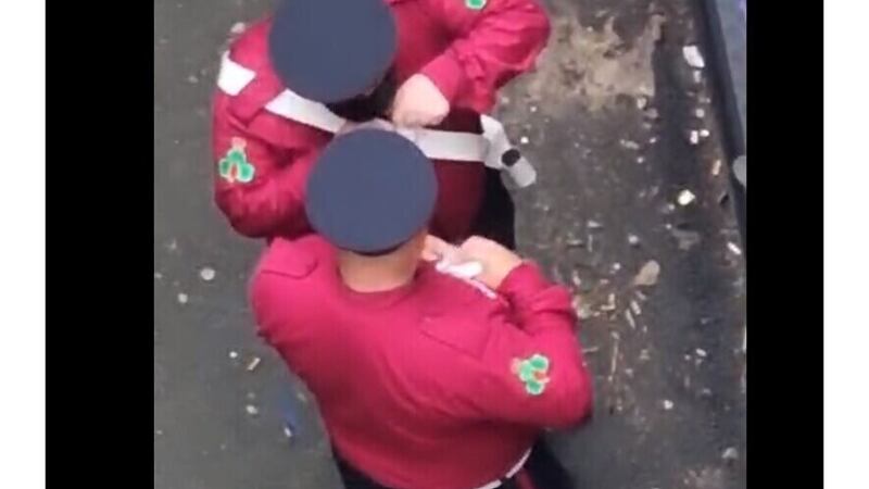 The pair in full band uniform were filmed in a back alley