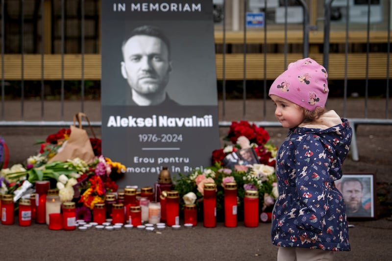 A child walks by a poster of Russian opposition leader Alexei Navalny (Vadim Ghirda/AP)