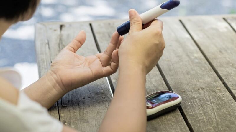 A diabetic woman uses a lancet to check her blood sugar level 