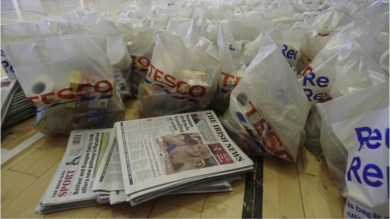 More than 300 donated copies of The Irish News were delivered to vulnerable families in west Belfast yesterday as part of a community group&#39;s food parcel run. Picture by Hugh Russell 