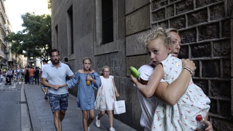 People flee the scene in Barcelona, Spain after a white van jumped the sidewalk in the historic Las Ramblas district. 13 people were reported killed PICTURE: Giannis Papanikos/AP 
