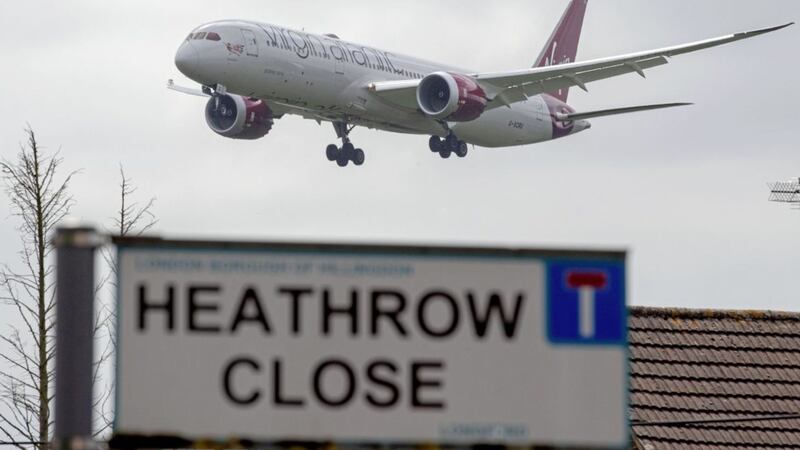 A plane lands at Heathrow Airport in west London, viewed from the village of Longford, as a third runway has been given the go-ahead by the Cabinet 