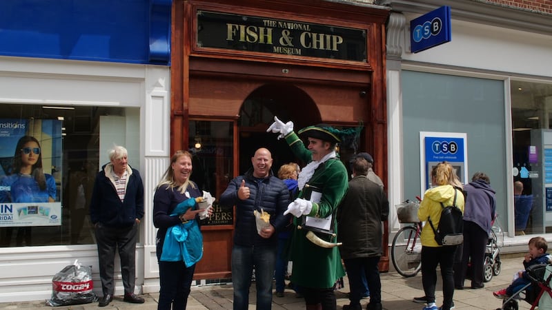 Customers pose with their fish and chips in York outside the National Fish & Chip Museum