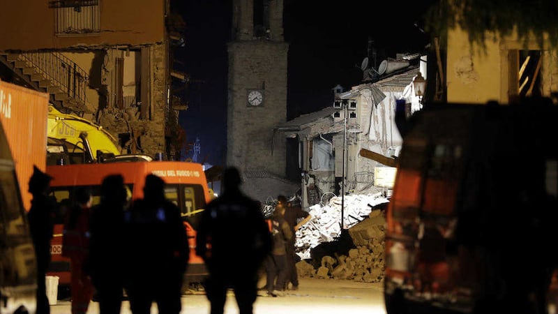 Rescuers stand among debris and the bell tower of Amatrice in central Italy PICTURE: Andrew Medichini/AP 