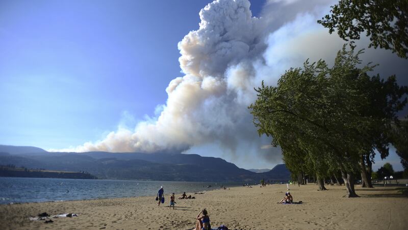 Smoke from a wildfire is seen over Okanagan Lake from Kelowna, British Columbia (Joe O’Connal/The Canadian Press via AP)