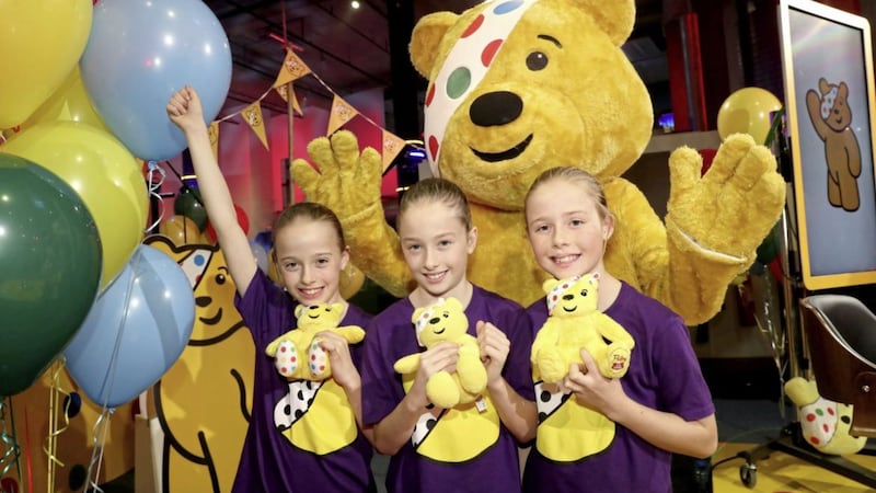 Triplets Armani, Tiara and Saffarah Mitchell, some of the 129 young people from Northern Ireland who performed in a choir at this year&rsquo;s BBC Children in Need, pictured with Pudsey Bear. Photo by William Cherry/Presseye 