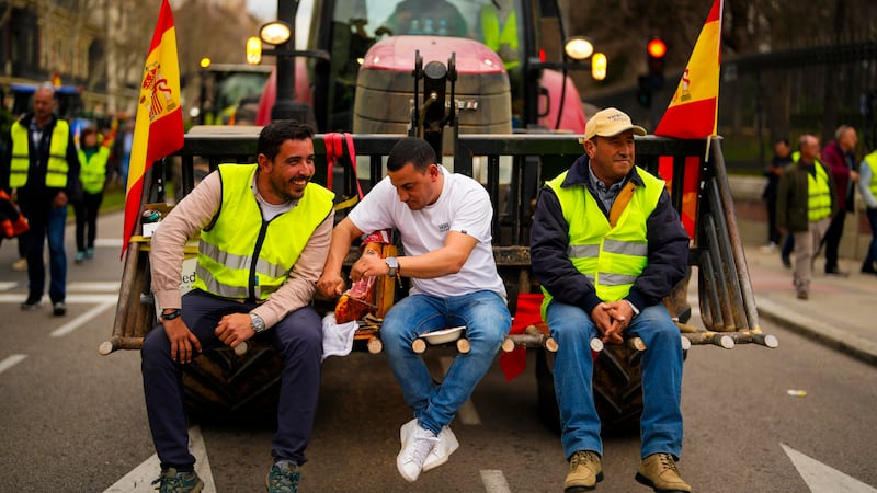Farmers sit on a tractor during a protest in Madrid, Spain (AP)
