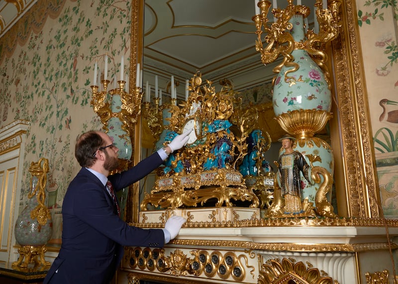 A Horological Conservator adjusts a late-18th-century mantel clockknown as the Kylin clock in the Yellow Drawing Room in the EastWing of Buckingham Palace (Royal Collection Trust / © His Majesty King Charles III 2024.)
