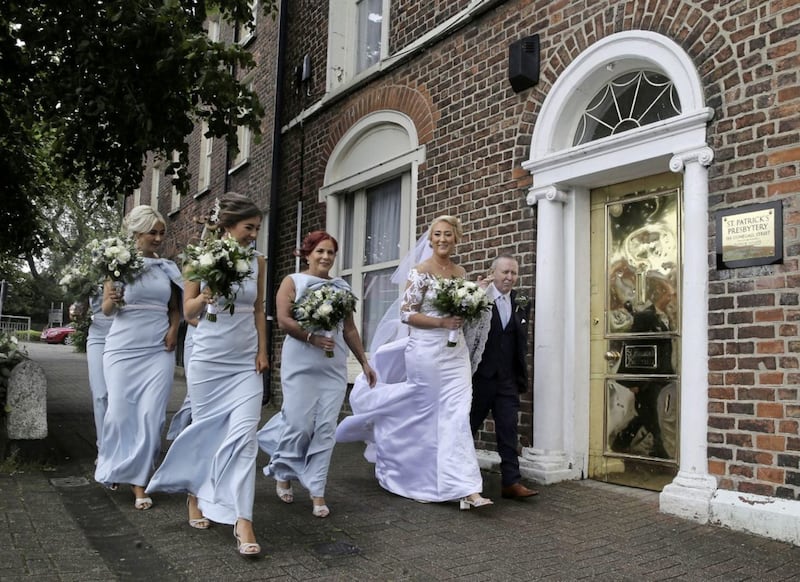Get Me To The Church On Time. Bride Frances Nugent walks to her wedding in St Patrichk&Atilde;&cent;&Acirc;?&Acirc;?s Church Donegal Street in North Belfast with her father Jim and bridesmaids.Picture by HUgh Russell. 