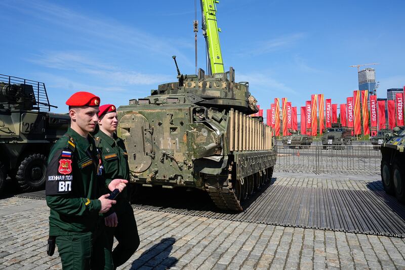 Russian soldiers walk past a M2A2 Bradley fighting vehicle that belonged to the Ukrainian army which has gone on display in Moscow (Alexander Zemlianichenko/AP)