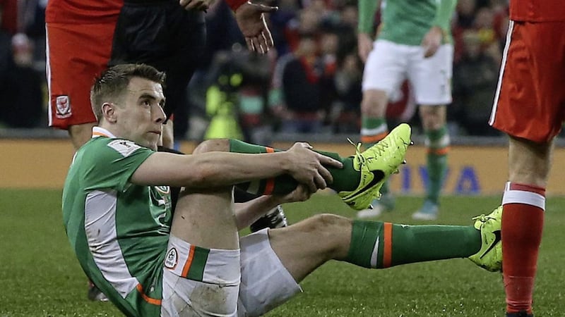 Republic of Ireland&#39;s Seamus Coleman holds his leg after a horrific challenge from Wales&#39; Neil Taylor 