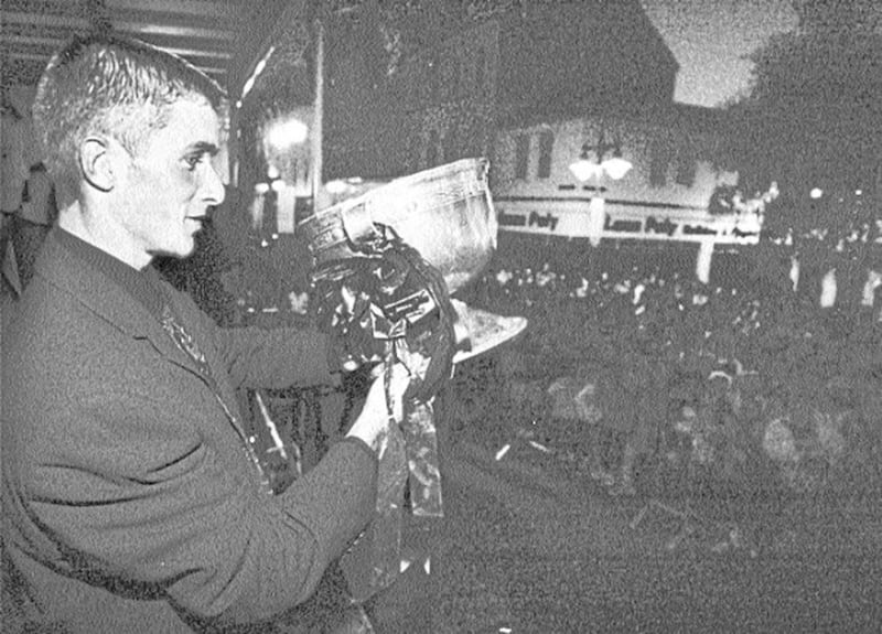 CUP WINNERS... Down minor captain Liam Doyle shows off the Tom Markham Cup to the assembled crowd in Newry last night 