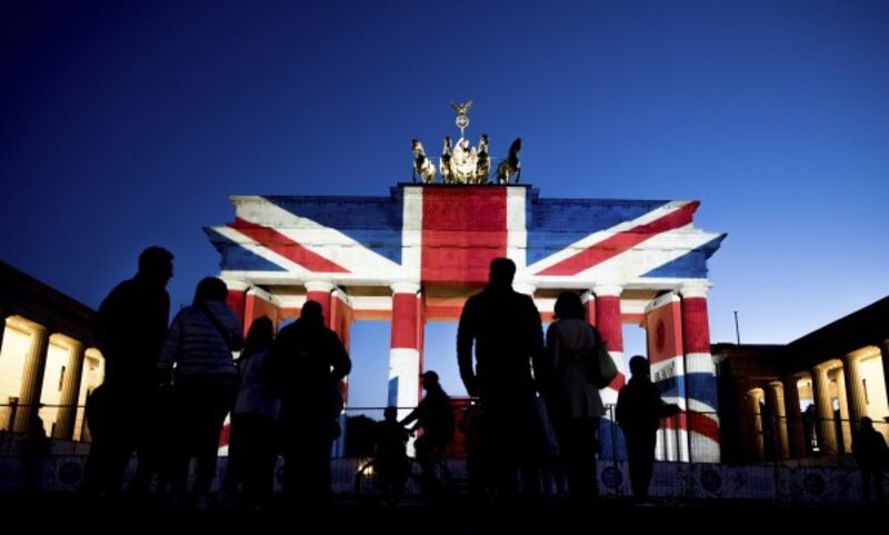 People view the Brandenburg Gate in Berlin after it was illuminated in the colors of the British union flag 