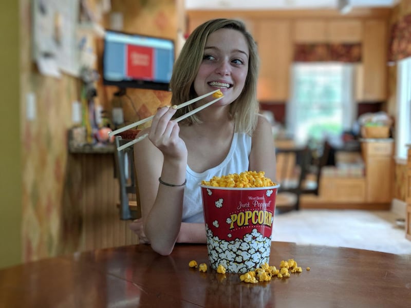 Eating popcorn with chopsticks.