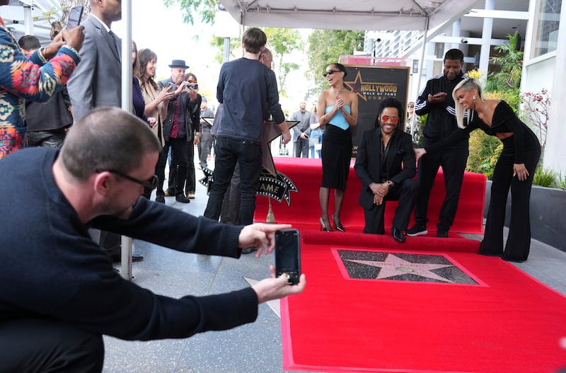 Channing Tatum, far left, takes a picture of Zoe Kravitz, from left center, Lenny Kravitz and Denzel Washington at a ceremony honouring Lenny Kravitz with a star on the Hollywood Walk of Fame