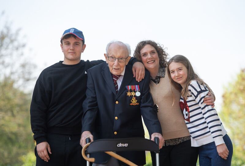 File photo dated 16/04/2020 of the then 99-year-old war veteran Captain Tom Moore, with (left to right) grandson Benji, daughter Hannah Ingram-Moore and granddaughter Georgia, at his home in Marston Moretaine, Bedfordshire, after he achieved his goal of 100 laps of his garden. Captain Sir Tom Moore has died at the age of 100 after testing positive for Covid-19, his daughters Hannah and Lucy said in a statement. Issue date: Tuesday February 2, 2021