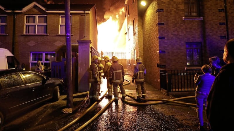 Firefighters dampen nearby homes last year as a loyalist bonfire at Ravenscroft Avenue in east Belfast 