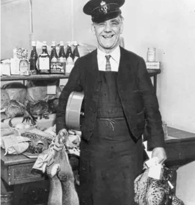 A postman in 1936 holding rabbits and pheasants ready to be posted 