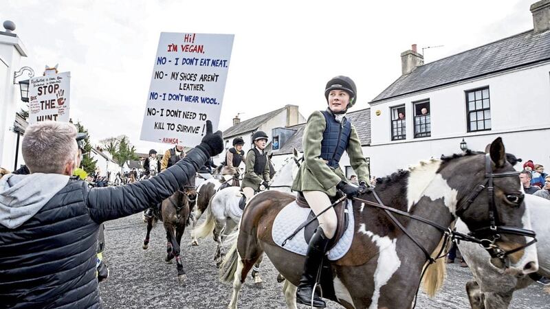 A young rider reads the placard of a vegan activist at the North Down new year Hunt in Crawfordsburn, Co Down. Picturey by Liam McBurney/PA 