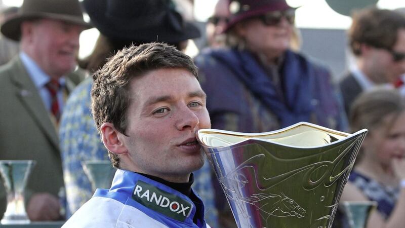 Grand National-winning jockey Derek Fox kisses a ringer for the Uefa Cup after his success on One for Arthur on Saturday <br />Picture by PA
