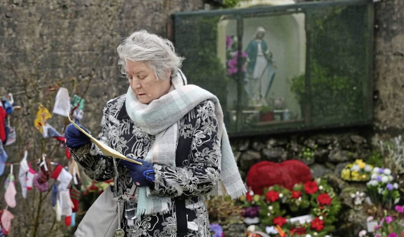 Carmel Larkin, who was born in the Tuam Mother and Baby home in 1949, holds a statement of apology from the Bon Secure Sisters at the grotto on an unmarked mass grave at the site last week. Picture by Niall Carson/PA 